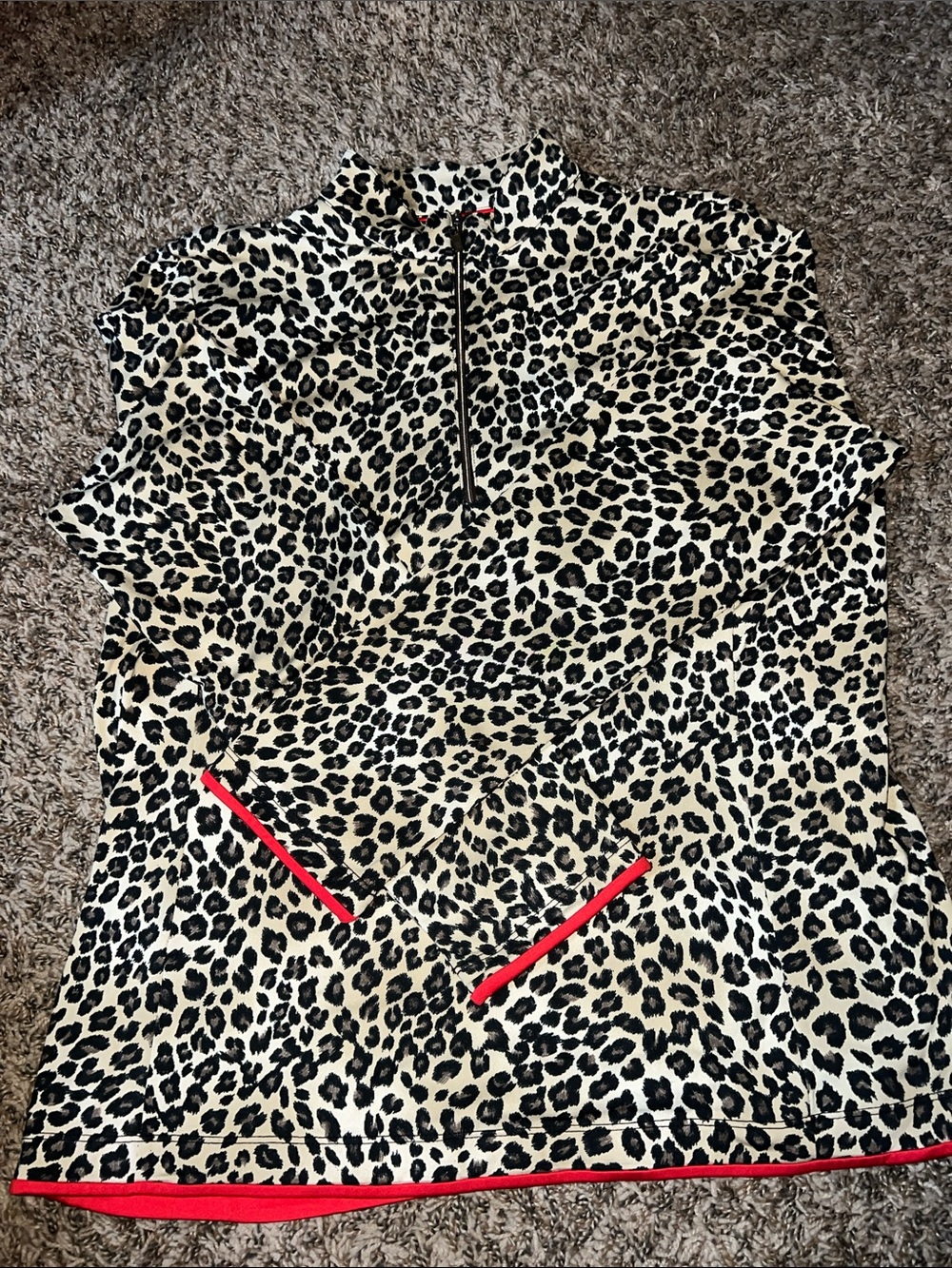 3/4 zip leopard print athletic pullover with red trim detail.